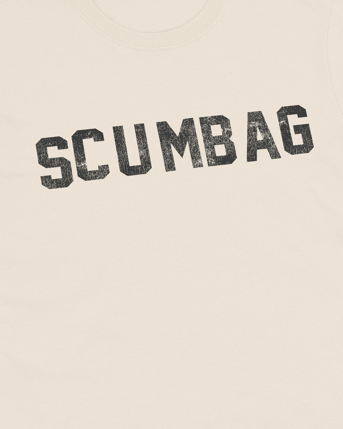 Close-up of cracked black varsity SCUMBAG lettering printed on natural t-shirt fabric