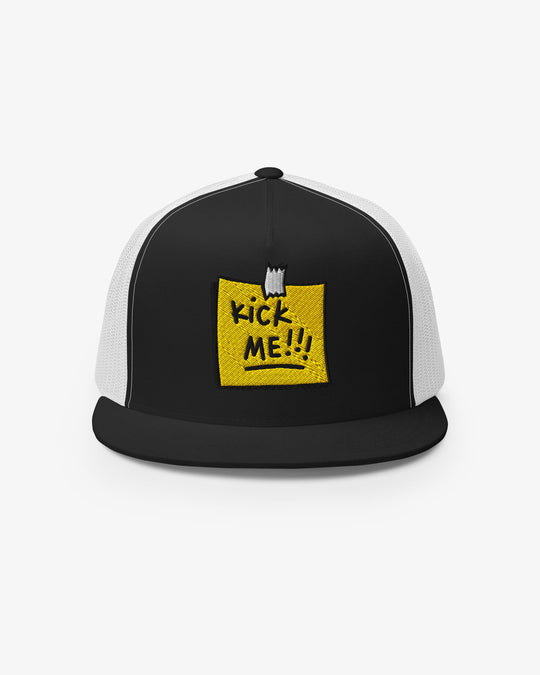 Black and white trucker cap with embroidered Kick Me!!! sticky-note graphic, front view