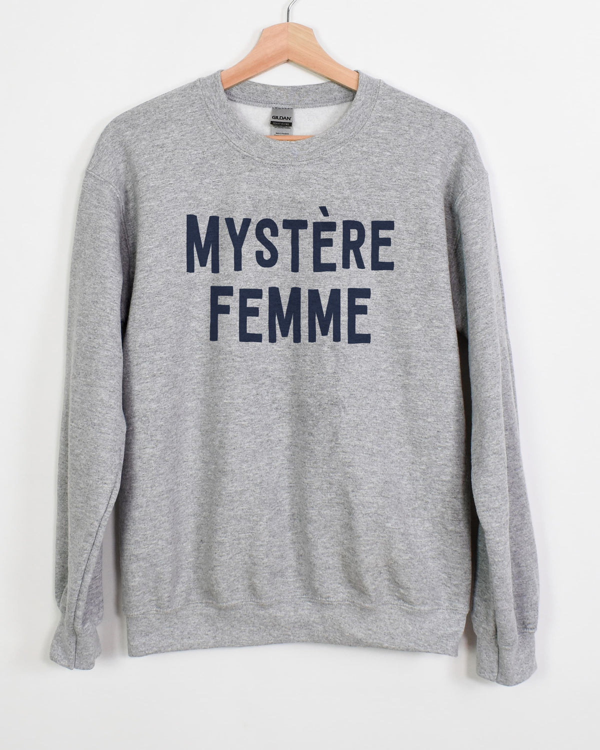 Mystère Femme sweatshirt in sport grey with navy lettering on a hanger