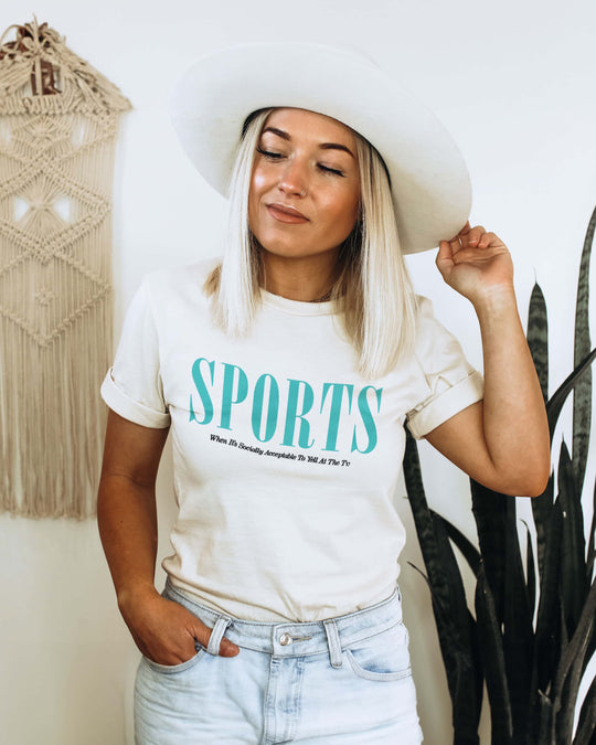 Sports t-shirt with teal "SPORTS" wordmark, worn by a model